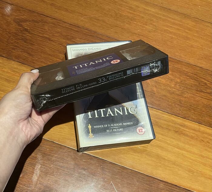 Hand holding vintage Titanic VHS tapes, a collectible item that remains valuable.