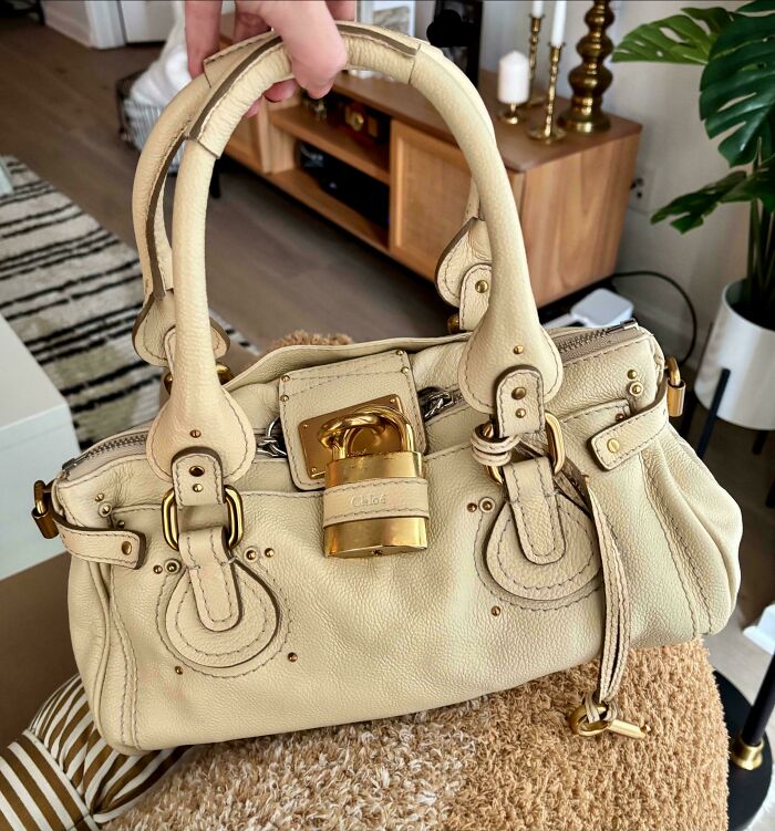 Vintage designer handbag with gold accents on a stylish interior background.