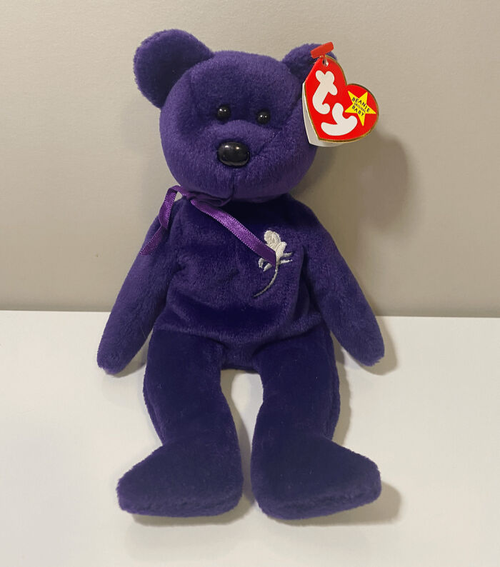 Vintage purple plush bear with a tag, a collectible item.