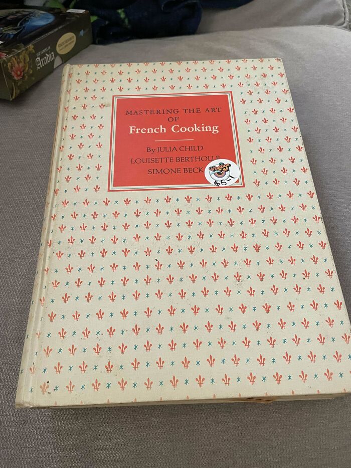 Vintage book "Mastering the Art of French Cooking" on a table.