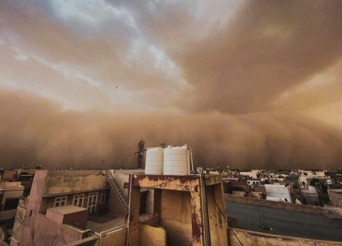 Sandstorm sweeping over a city, showcasing nature's powerful and terrifying force.