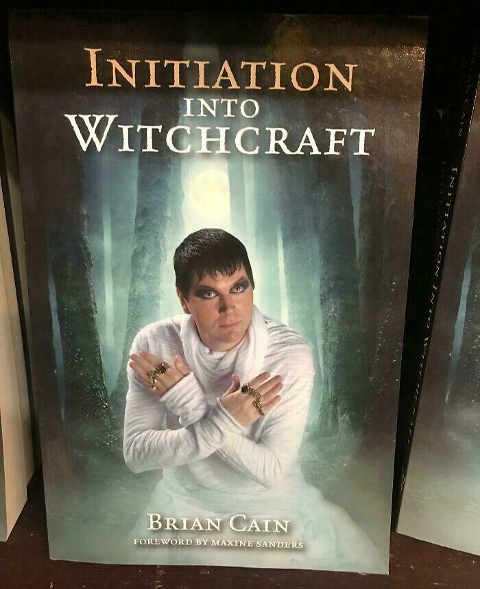 Terrible book cover titled "Initiation Into Witchcraft" featuring a person in white, with dark make-up, set in a mystical forest.