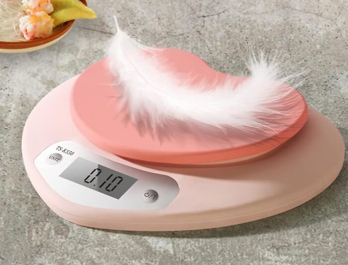 Digital scale with a feather on it, showcasing accuracy in weighing light objects.