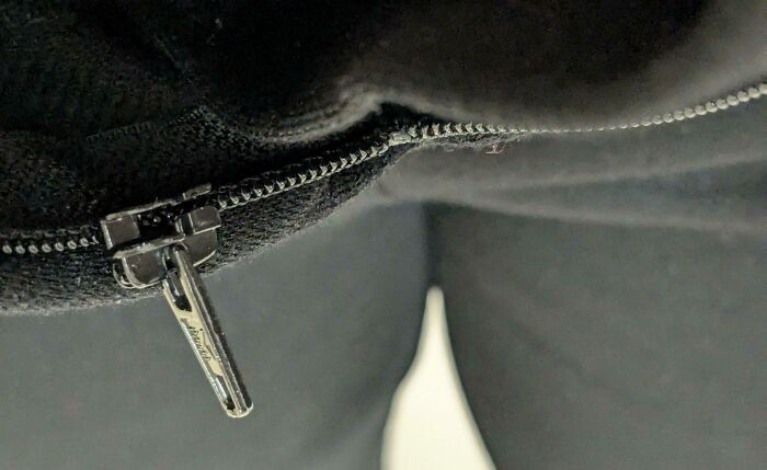 Stuck zipper on black fabric, highlighting a workday mishap.