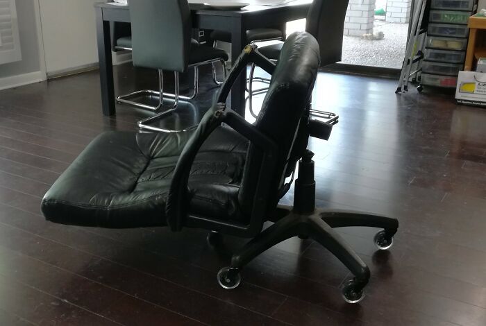 Broken office chair on its side in a workspace, illustrating a worst day at work scenario.
