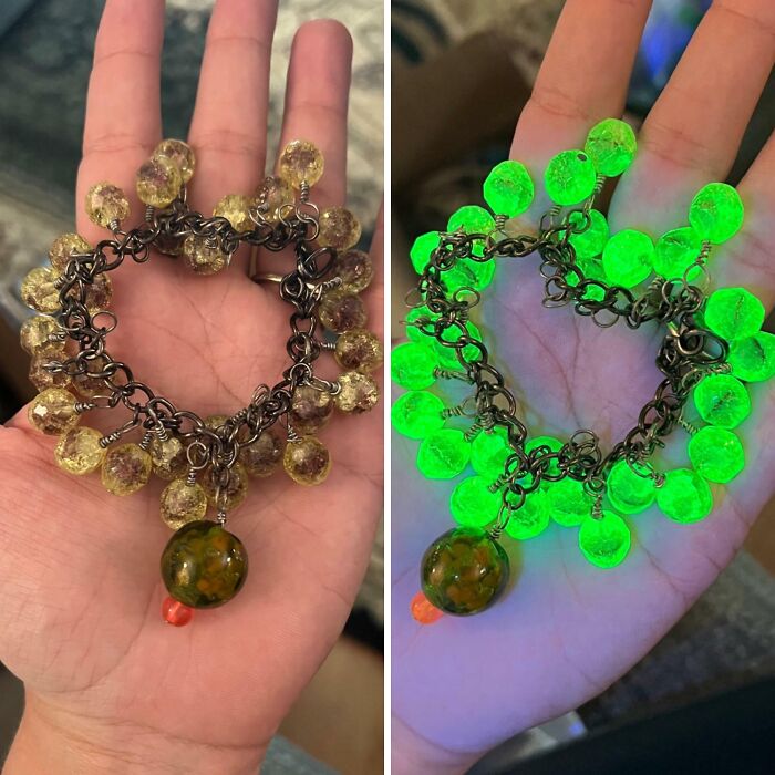 Vintage amber bead bracelet shown glowing under UV light in hand.