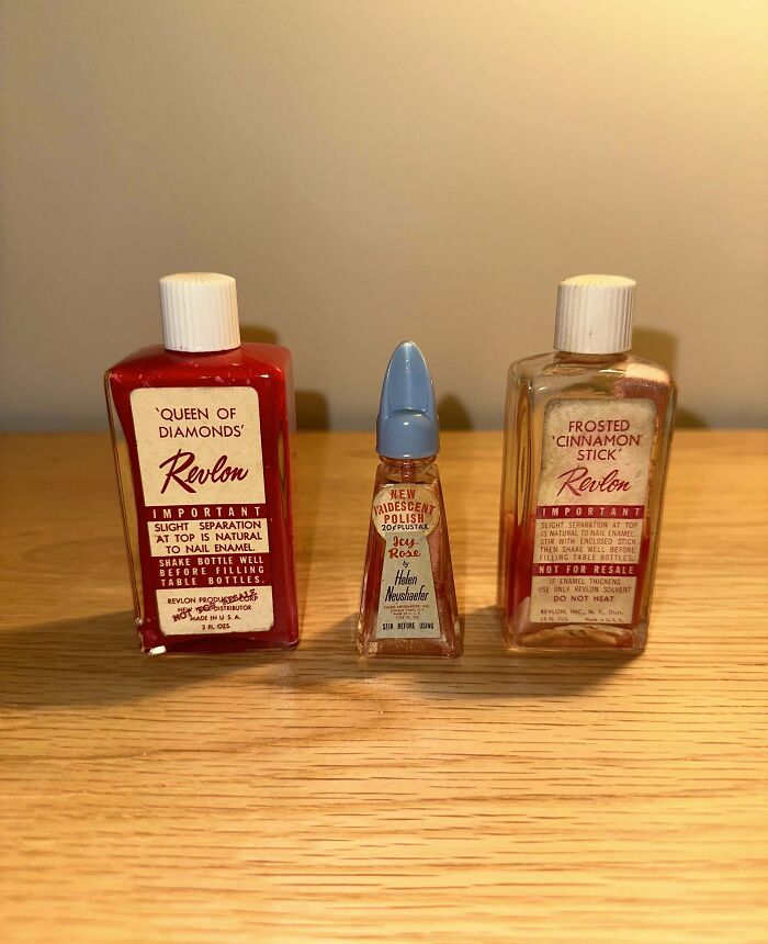 Vintage Revlon nail polish bottles including Queen of Diamonds and Frosted Cinnamon Stick on a wooden surface.