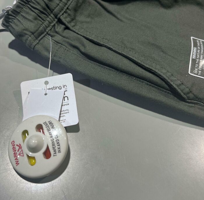 Security tag left on pants due to careless colleagues.
