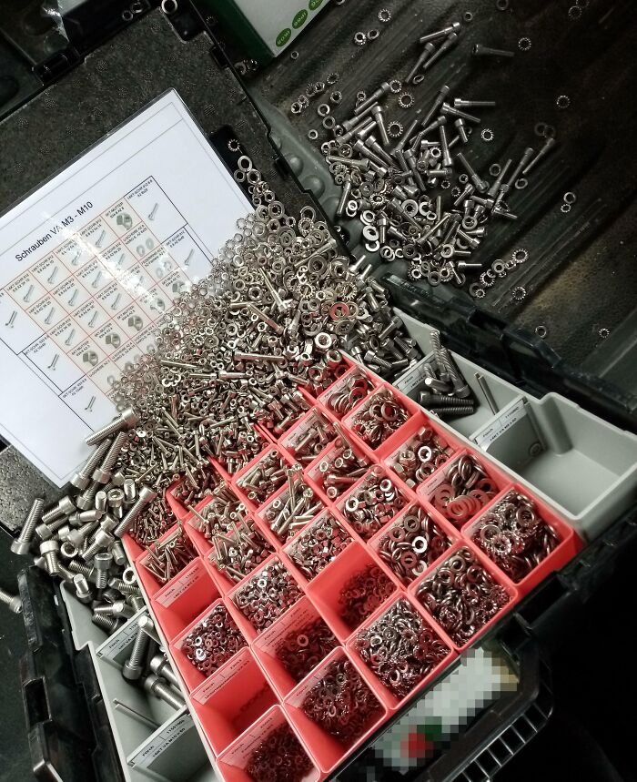 Disorganized screws and washers in a tool box, illustrating frustration with worst colleagues.