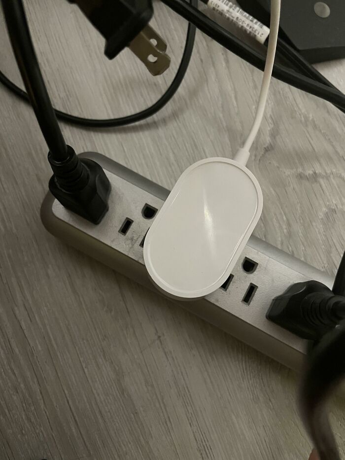 Power strip covered by a bulky plug, exemplifying disastrous design choices.
