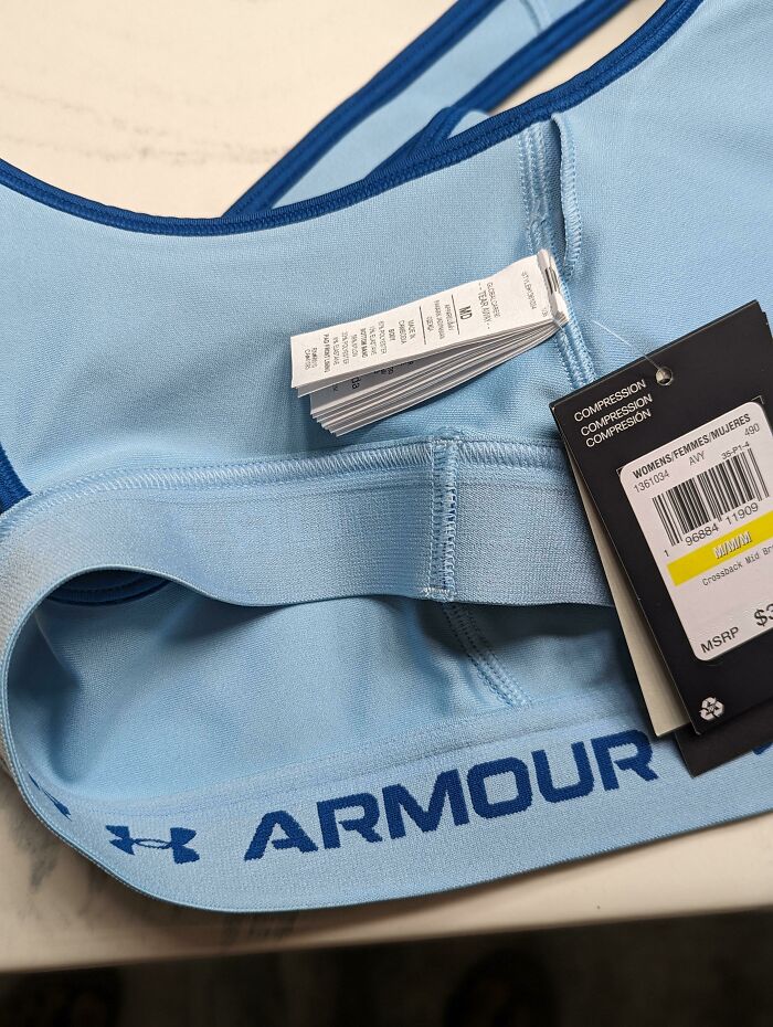 Blue sports bra with text labels, showcasing a design error.