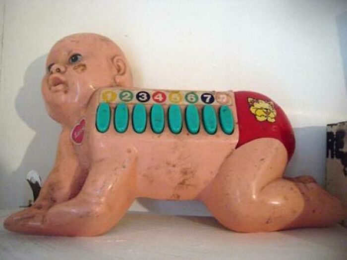 Bizarre design of a baby-shaped toy with numbered buttons on its back, showcasing disastrous design concepts.