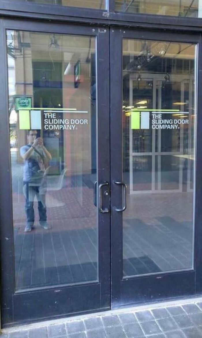 Glass doors with handles, labeled "The Sliding Door Company," showcasing a disastrous design.