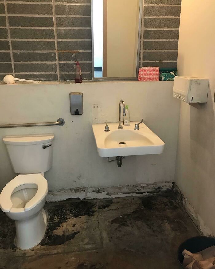 American school restroom with a sink, toilet, and peeling floor.