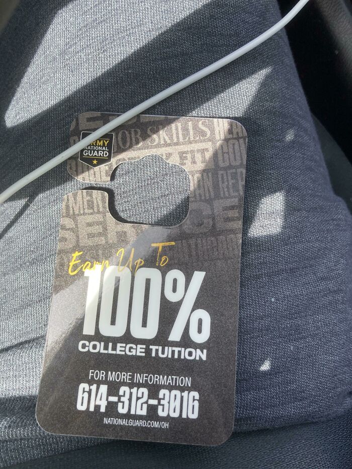 National Guard flyer offering up to 100% college tuition on a grey fabric background.