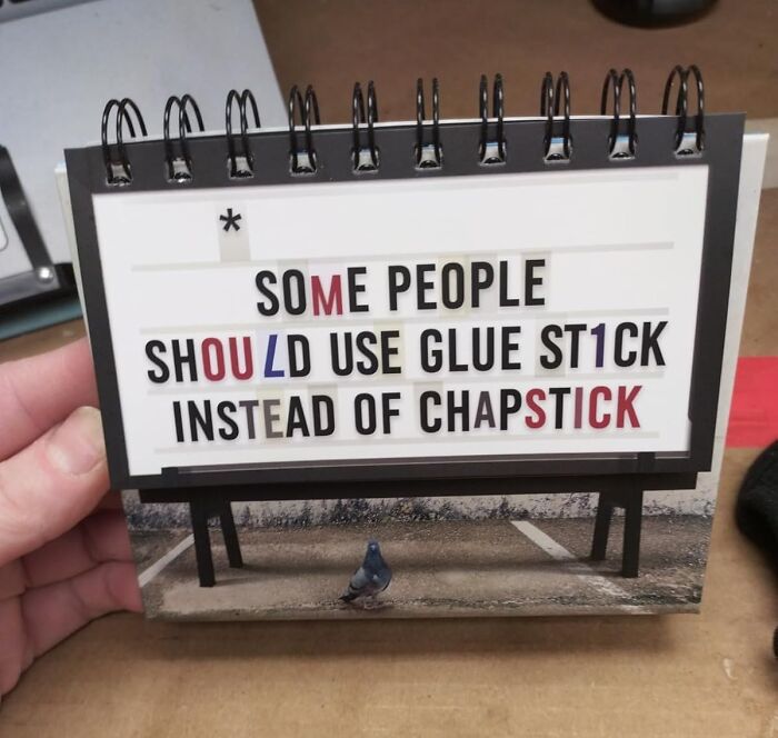 Desk sign humor suggesting glue stick over chapstick, illustrating office Olympics humor.