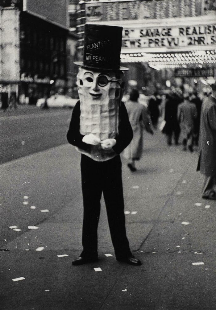 Person in a Mr. Peanut costume on a city street, evoking an unsettling feeling from the past.