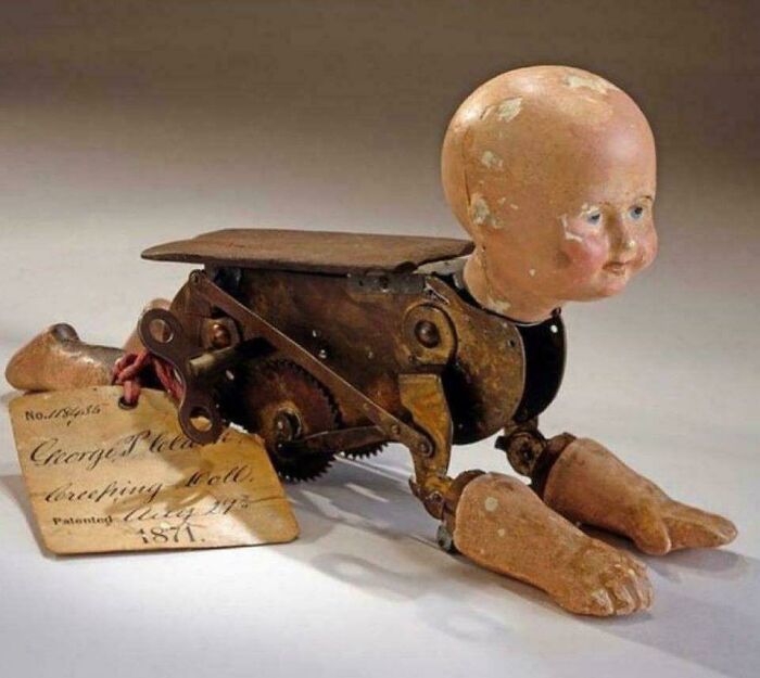 Creepy vintage crawling doll with mechanical body and weathered face.