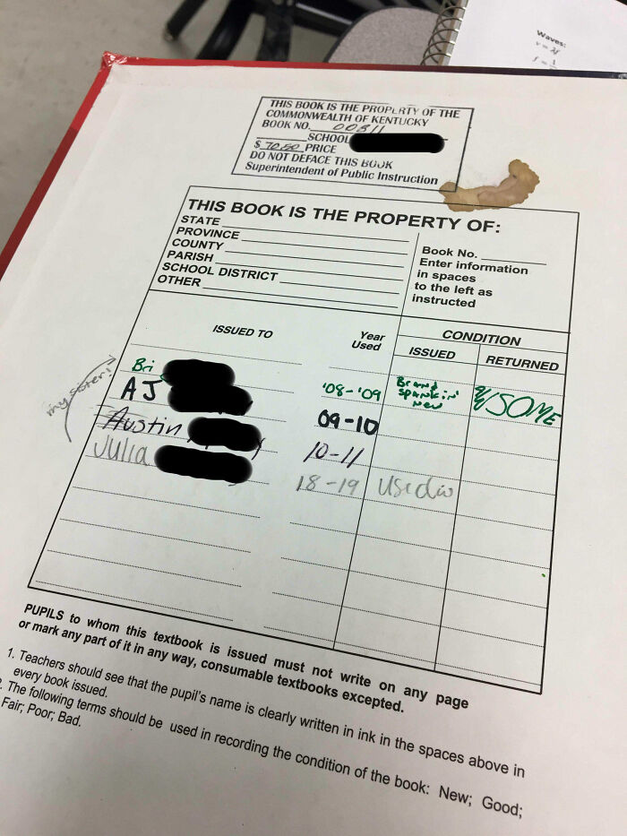 American school textbook with student names and condition notes, including a coffee stain and used condition marked as "AWESOME".