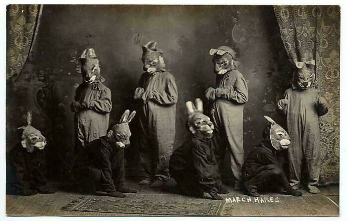 Vintage photo of people in unsettling rabbit costumes, posing in a staged setting.