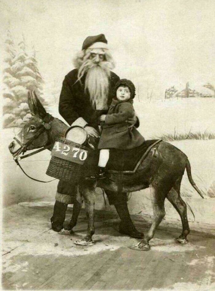 Unsettling vintage photo of a bearded man and child on a stuffed donkey in a winter scene.