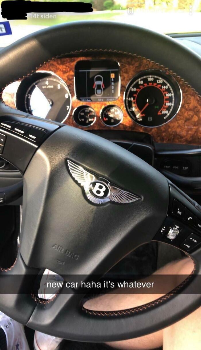Luxury car steering wheel with casual text overlay, highlighting wealth disparity.