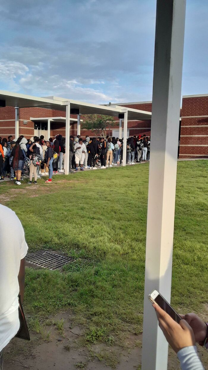 Students lined up outside an American school building, showcasing campus life.