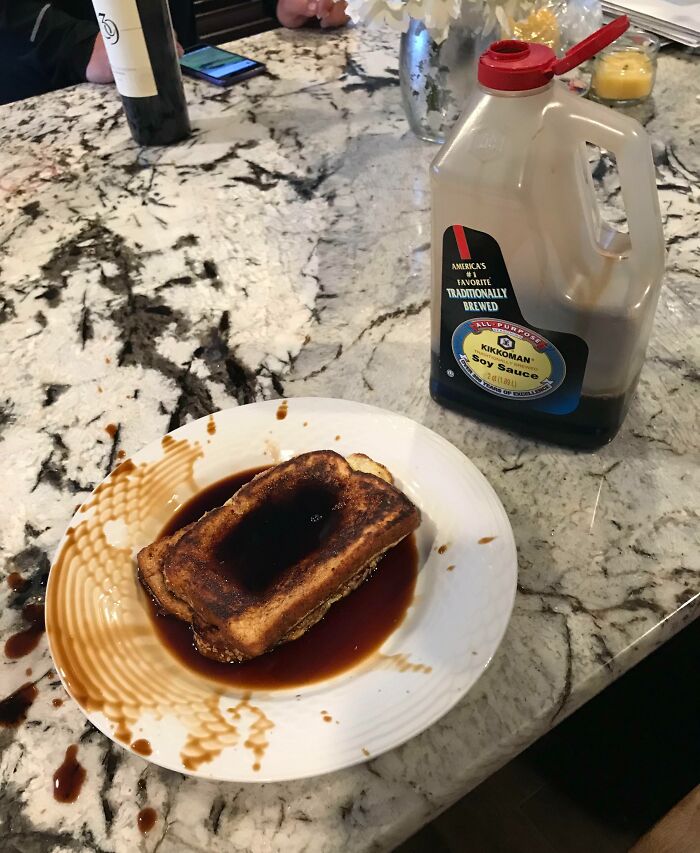 Grilled cheese soaked in soy sauce spill on a marble counter, illustrating a bad day mishap.