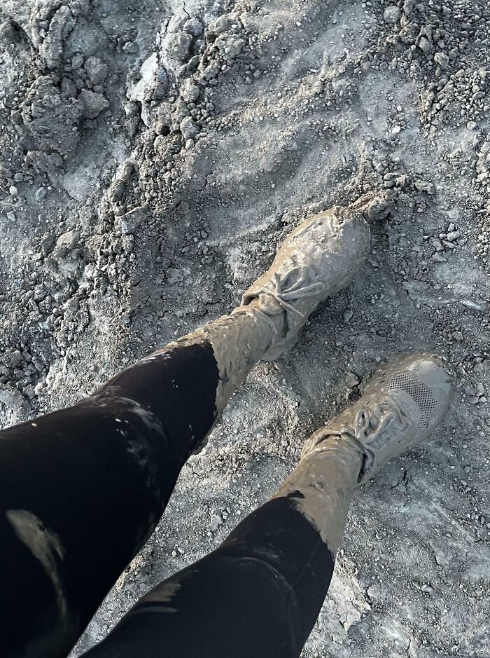 Zapatos cubiertos de lodo tras cometer errores en terreno fangoso.