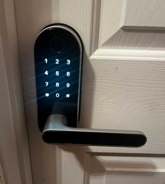 Digital door lock with keypad, mounted on a white door, representing contractor secrets.