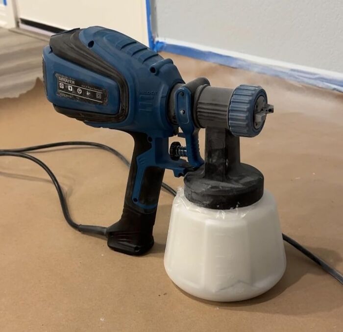 Paint sprayer tool on a construction site floor.