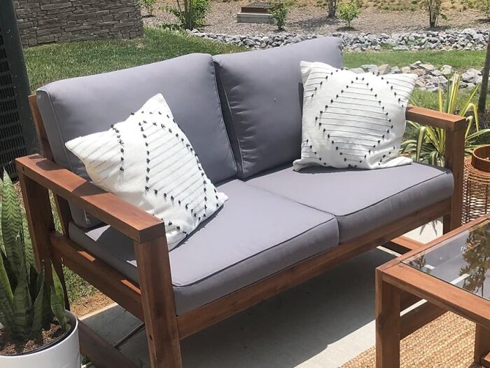 Outdoor sofa with gray cushions and pattern pillows, perfect for backyard dreams.