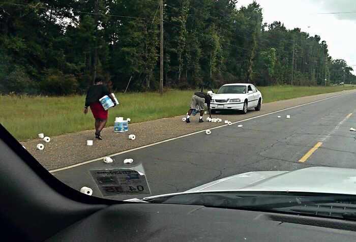 Personas recogen rollos de papel en la carretera tras un error del coche.