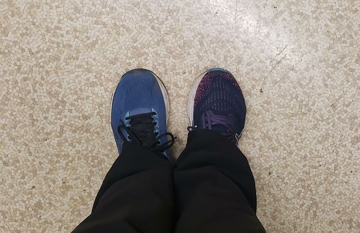 Mismatched shoes on a tiled floor, illustrating someone having a worse day.