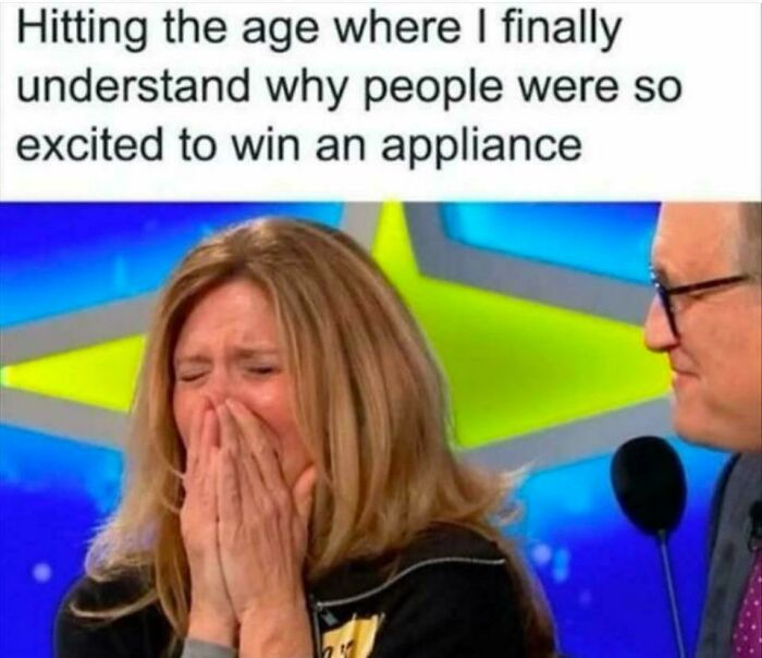 Woman realizing adulthood excitement over appliances, standing with a host on a game show set.