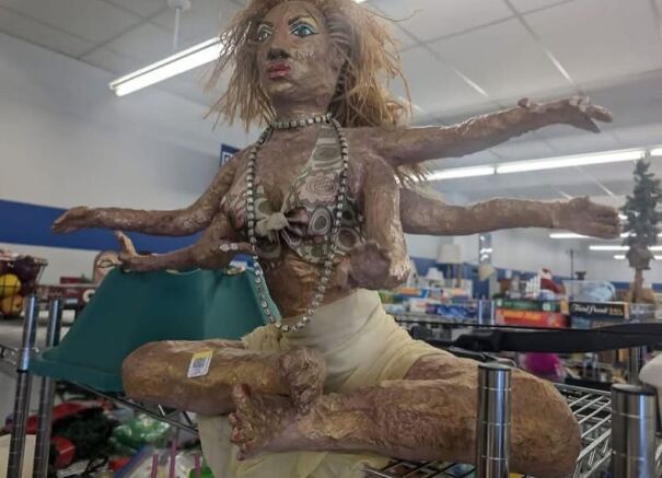 A six-armed, handcrafted statue with a beaded necklace found while thrifting in a store aisle.
