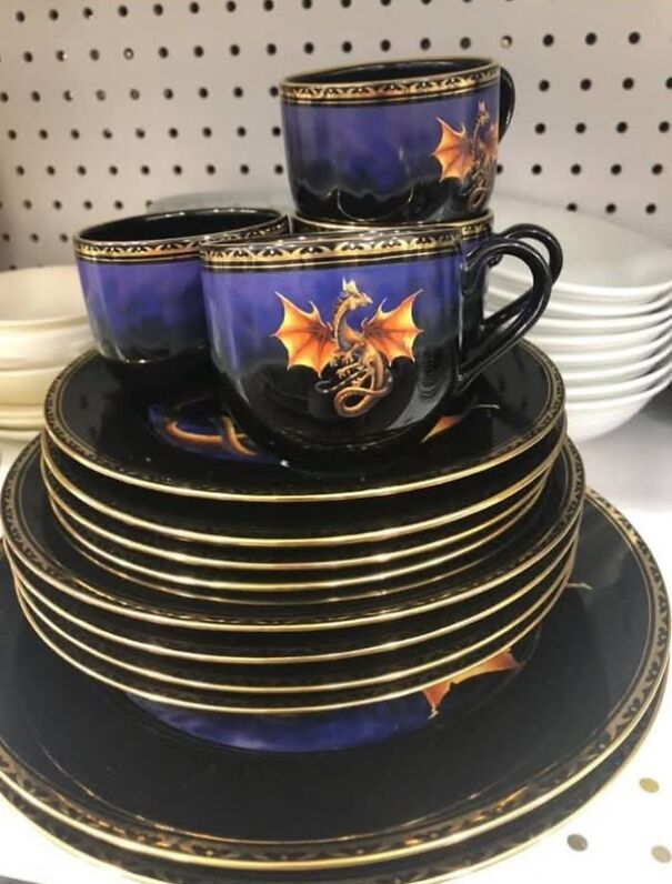 Dragon-themed thrifted dishware set with purple accents stacked on a shelf.