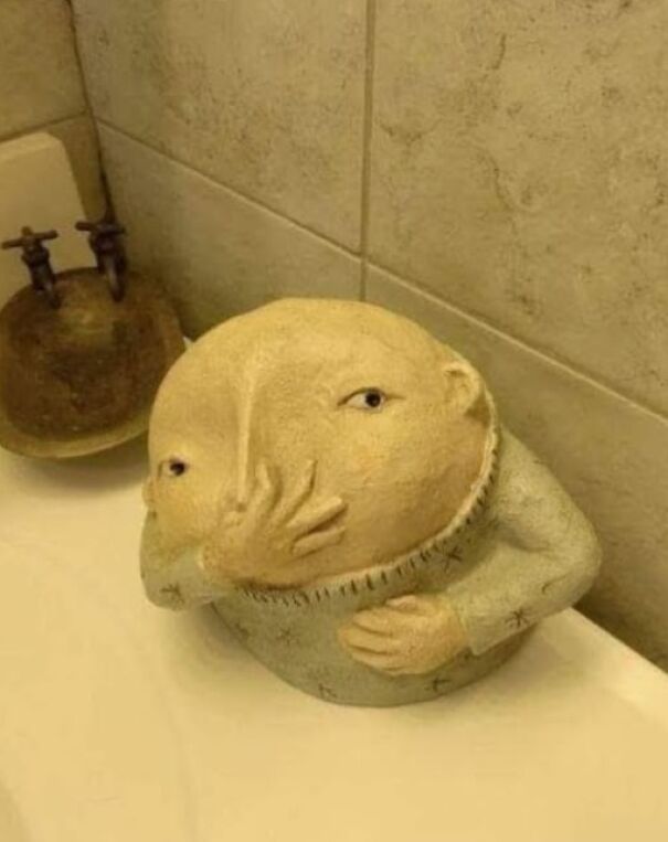 Strange item found while thrifting, resembling a whimsical figure with hands on its face.