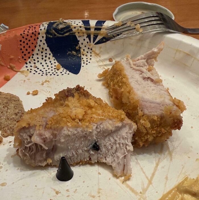 Disgusting find in breaded chicken: plastic piece stuck inside.