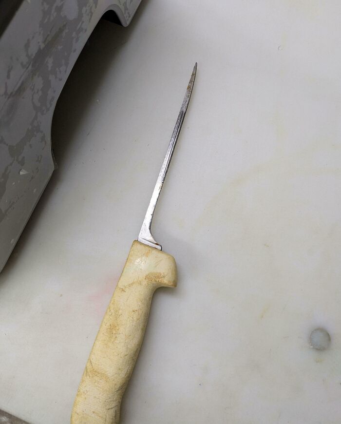 Cuchillo desgastado por el tiempo sobre una superficie blanca.