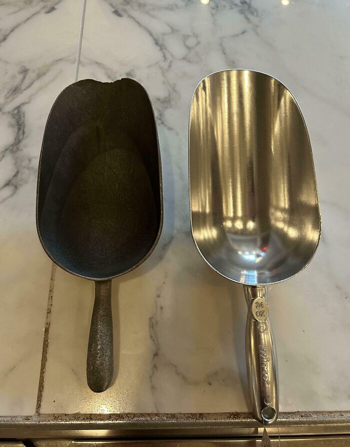 Dos palas metálicas, una desgastada por el tiempo y otra nueva, sobre una superficie de mármol.