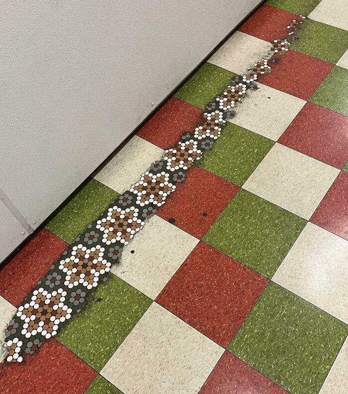 Azulejos desgastados revelan un camino diferente en el suelo, mostrando el efecto del tiempo.