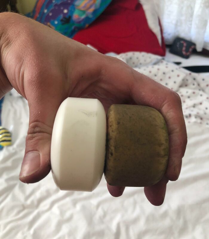 Ruedas de patineta, una nueva y otra desgastada por el tiempo, en una mano sobre un fondo colorido.