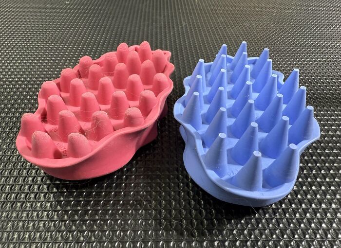 Worn-down pink grooming brush next to a new blue one, showing effects of time on belongings.