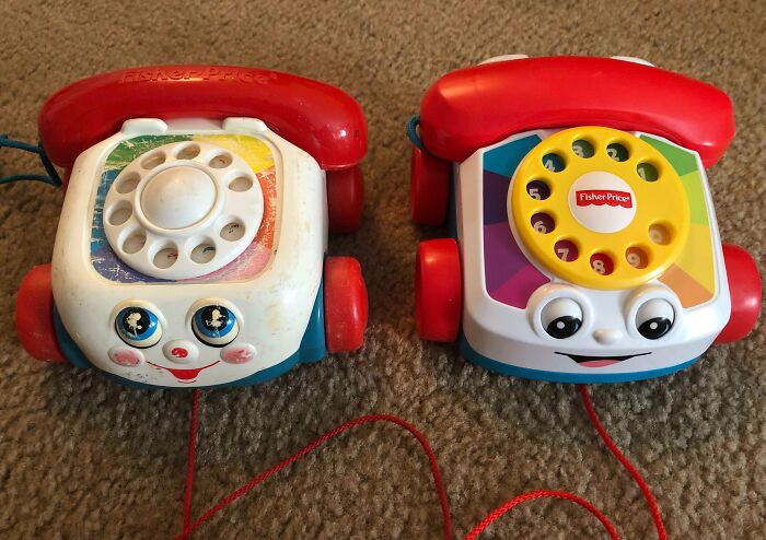 Two Fisher Price toy phones; one worn by time, the other new.