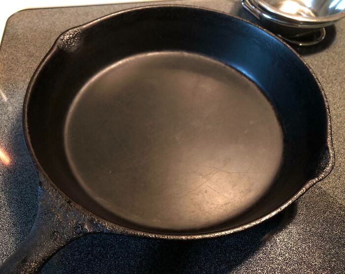 Worn-down cast iron skillet showcasing the effects of time and frequent use.