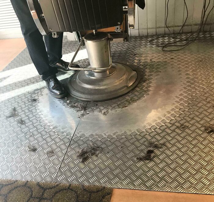 "Silla de barbero sobre suelo desgastado por el tiempo en una peluquería."