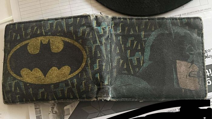 Worn-down Batman-themed wallet showing signs of use over time.