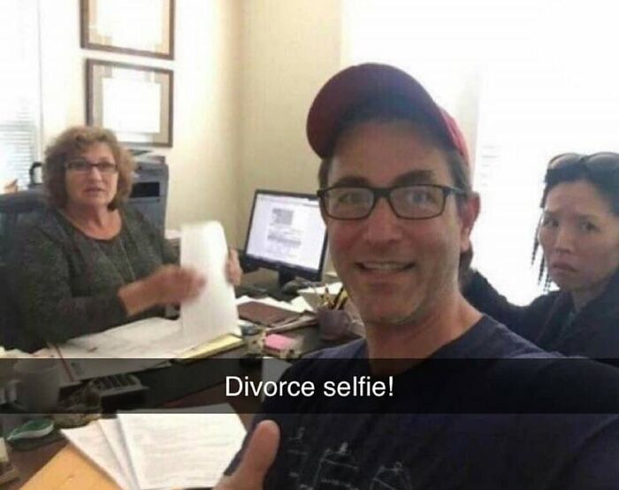 Man taking a selfie in an office with two women, captioned "Divorce selfie!" Humor meme moment.