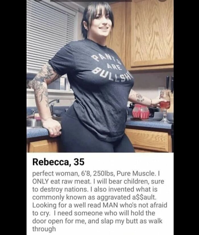 Woman in kitchen humorously posing with a drink, wearing a humorous shirt, part of daily humor memes collection.